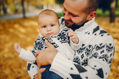 Sonbahar parkında oynayan sevimli bir aile.