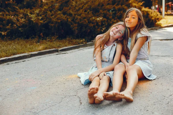 İki tatlı kız yaz parkında eğleniyor.