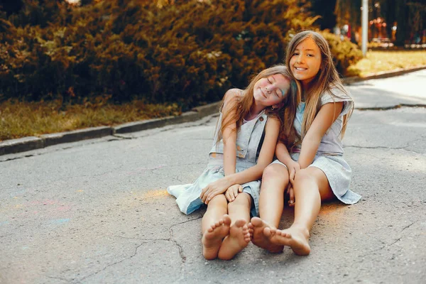 İki tatlı kız yaz parkında eğleniyor.