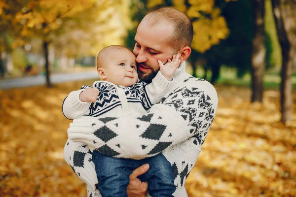 Sonbahar parkında oynayan sevimli bir aile.