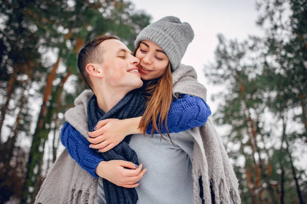 Söta och kärleksfulla par i en vinterskog — Stockfoto