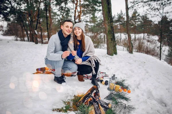 Roztomilý a milující pár v zimním lese — Stock fotografie