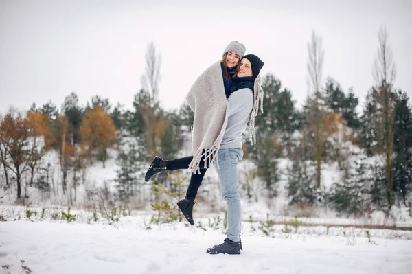 Söta och kärleksfulla par i en vinterskog — Stockfoto