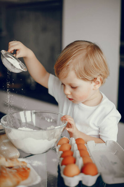 Little boy cook the dough for cookies