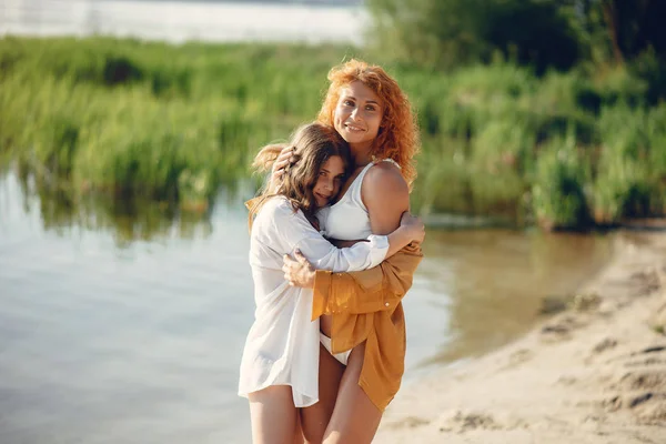 Mère sportive avec fille mignonne marchant près du lac — Photo