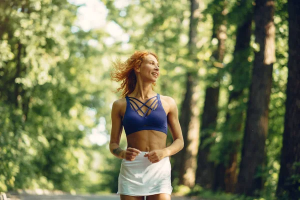 Beautiful woman training in a summer park