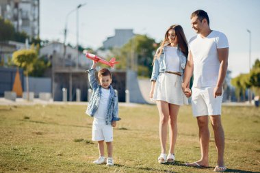 Yaz parkında oynayan sevimli bir aile.
