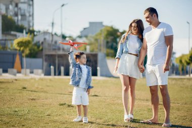 Yaz parkında oynayan sevimli bir aile.
