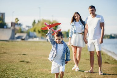 Yaz parkında oynayan sevimli bir aile.