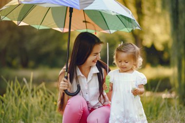 Anne ve kızı yaz parkında oynuyorlar.