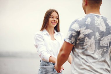 Güzel bir çift, sonbahar bulutlu bir parkta vakit geçirir.