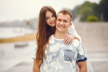 Güzel bir çift, sonbahar bulutlu bir parkta vakit geçirir.