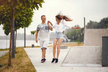 Güzel bir çift, sonbahar bulutlu bir parkta vakit geçirir.