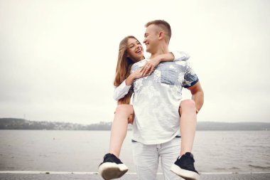 Güzel bir çift, sonbahar bulutlu bir parkta vakit geçirir.