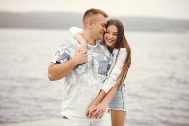 Güzel bir çift, sonbahar bulutlu bir parkta vakit geçirir.