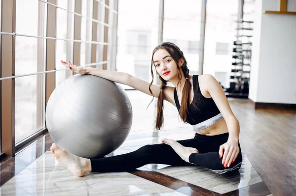 Una hermosa chica se dedica a un gimnasio —  Fotos de Stock