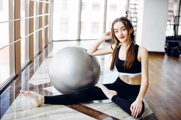 Una hermosa chica se dedica a un gimnasio —  Fotos de Stock