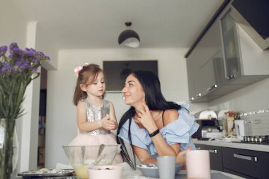 Aile mutfakta oturur ve kurabiye için hamur pişirir.