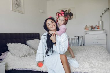 Anne ve kızı evde kafalarında bigudilerle