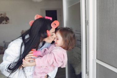 Anne ve kızı evde kafalarında bigudilerle