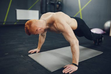 The pumped man is engaged in sports in the gym