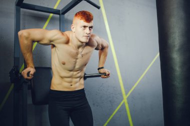 The pumped man is engaged in sports in the gym