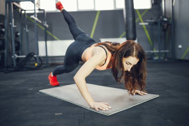 Beautiful tense girl doing in the gym