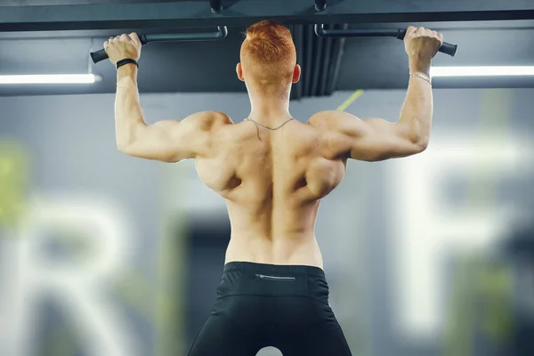 The pumped man is engaged in sports in the gym — 스톡 사진