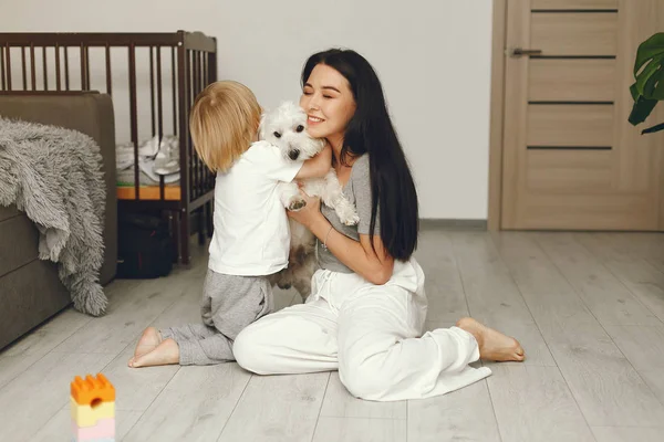 Matka a malý syn zábava doma se psem — Stock fotografie