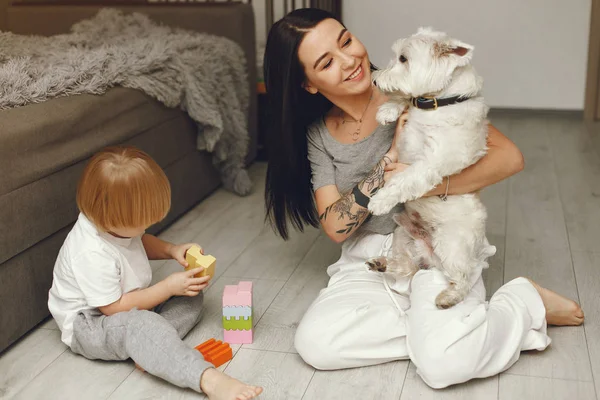 Mamma e piccolo figlio si divertono a casa con il cane — Foto Stock