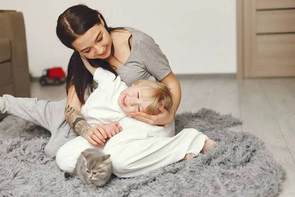 Matka a malý syn zábava doma s kočkou — Stock fotografie