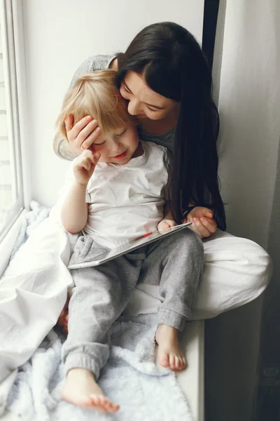 Mãe e filho pequeno sentados em um peitoril da janela — Fotografia de Stock