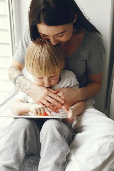 Mãe e filho pequeno sentados em um peitoril da janela — Fotografia de Stock