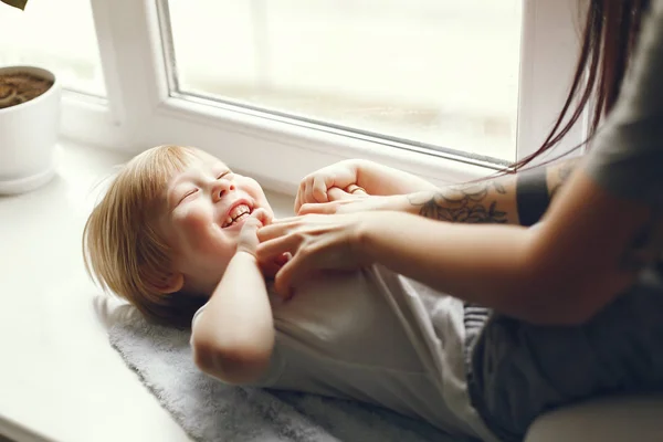 Mãe e filho pequeno sentados em um peitoril da janela — Fotografia de Stock