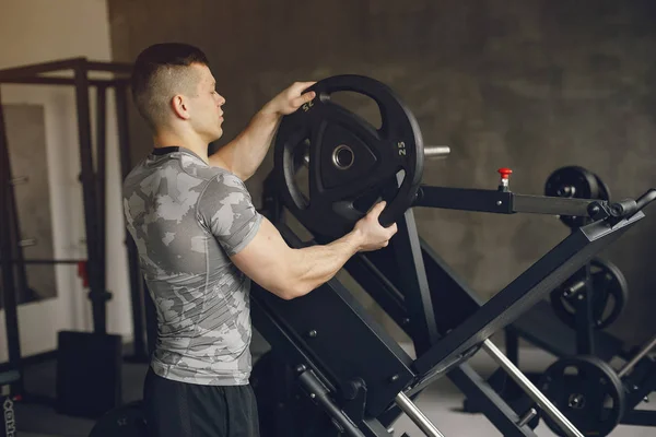 Un bell'uomo è impegnato in una palestra — Foto Stock