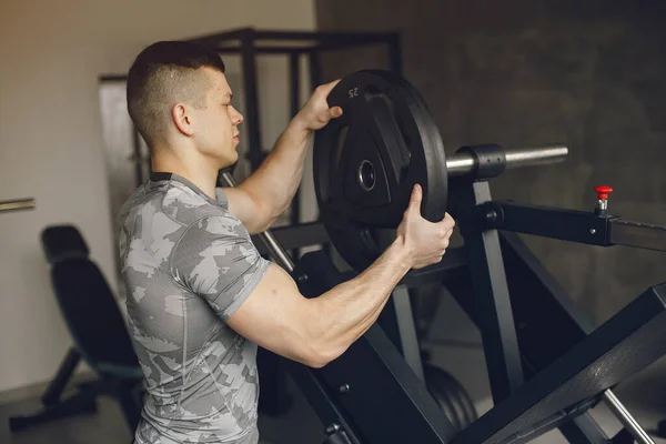 Un bell'uomo è impegnato in una palestra — Foto Stock