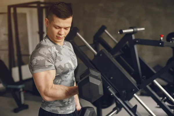 Un hombre guapo se dedica a un gimnasio —  Fotos de Stock