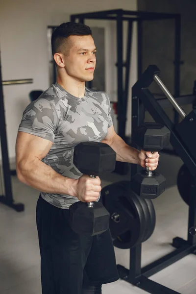 Un bell'uomo è impegnato in una palestra — Foto Stock