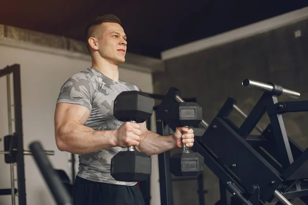 Un hombre guapo se dedica a un gimnasio —  Fotos de Stock