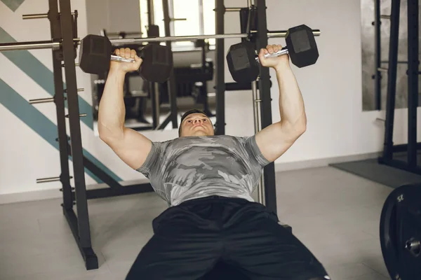 Un bell'uomo è impegnato in una palestra — Foto Stock