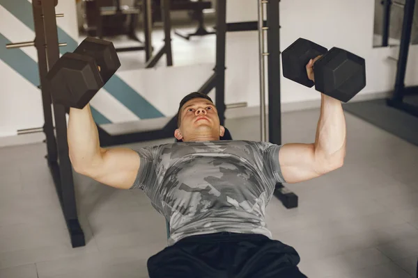 Un bell'uomo è impegnato in una palestra — Foto Stock