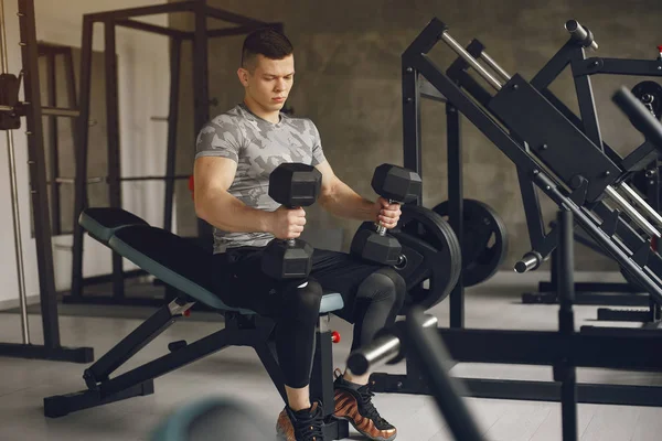 Un bell'uomo è impegnato in una palestra — Foto Stock