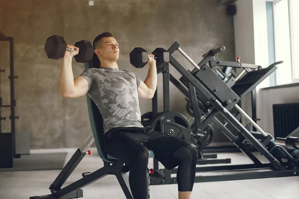 Un hombre guapo se dedica a un gimnasio —  Fotos de Stock