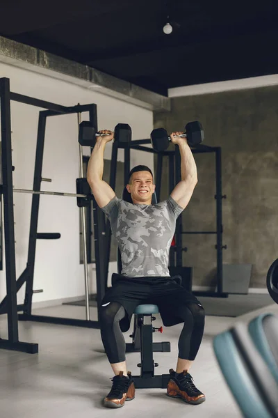 Un bell'uomo è impegnato in una palestra — Foto Stock