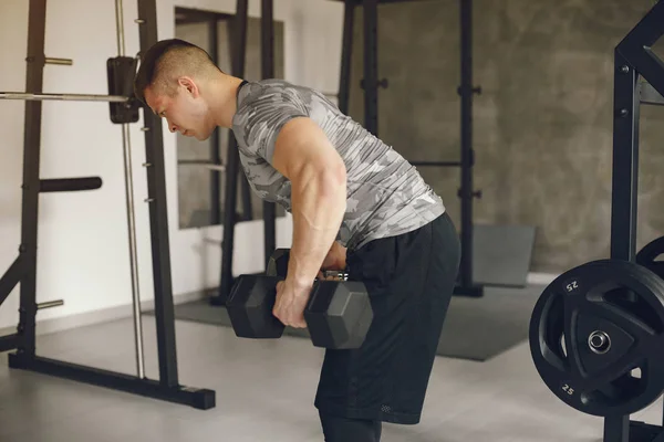 Un hombre guapo se dedica a un gimnasio —  Fotos de Stock