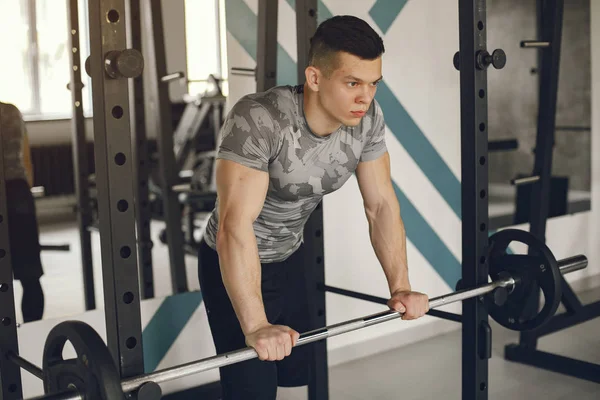 Un hombre guapo se dedica a un gimnasio —  Fotos de Stock