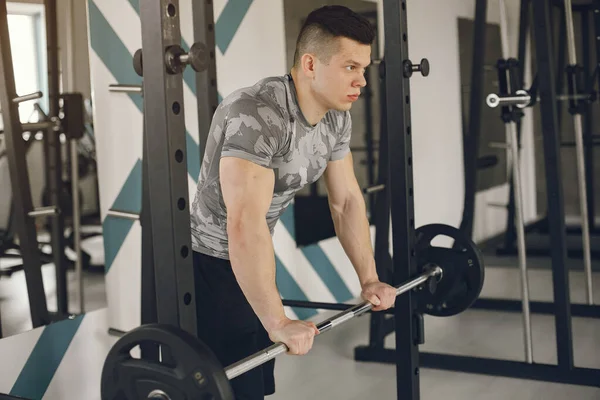 Un bell'uomo è impegnato in una palestra — Foto Stock