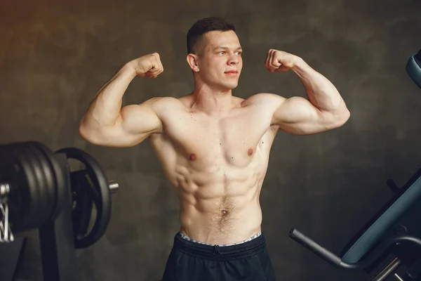 Ein schöner Mann ist in einem Fitnessstudio beschäftigt — Stockfoto