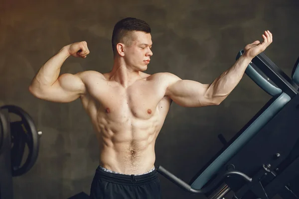 Un hombre guapo se dedica a un gimnasio — Foto de Stock