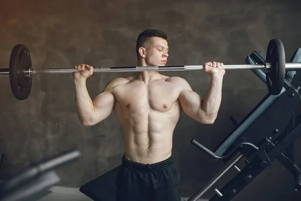 Un bell'uomo è impegnato in una palestra — Foto Stock